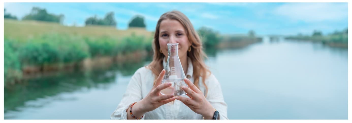 Studente onderzoekt een watermonster aan de waterkant