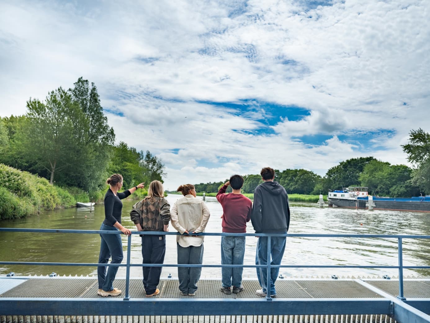 Studenten krijgen uitleg bij een sluiscomplex aan het water