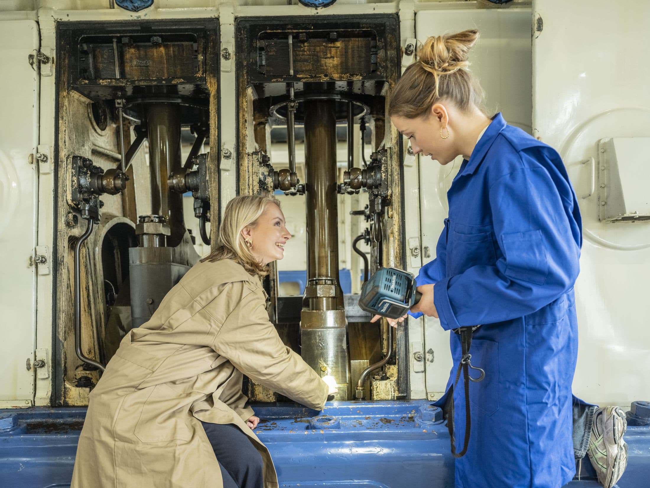 Twee mensen in werkkleding werken aan een technische installatie