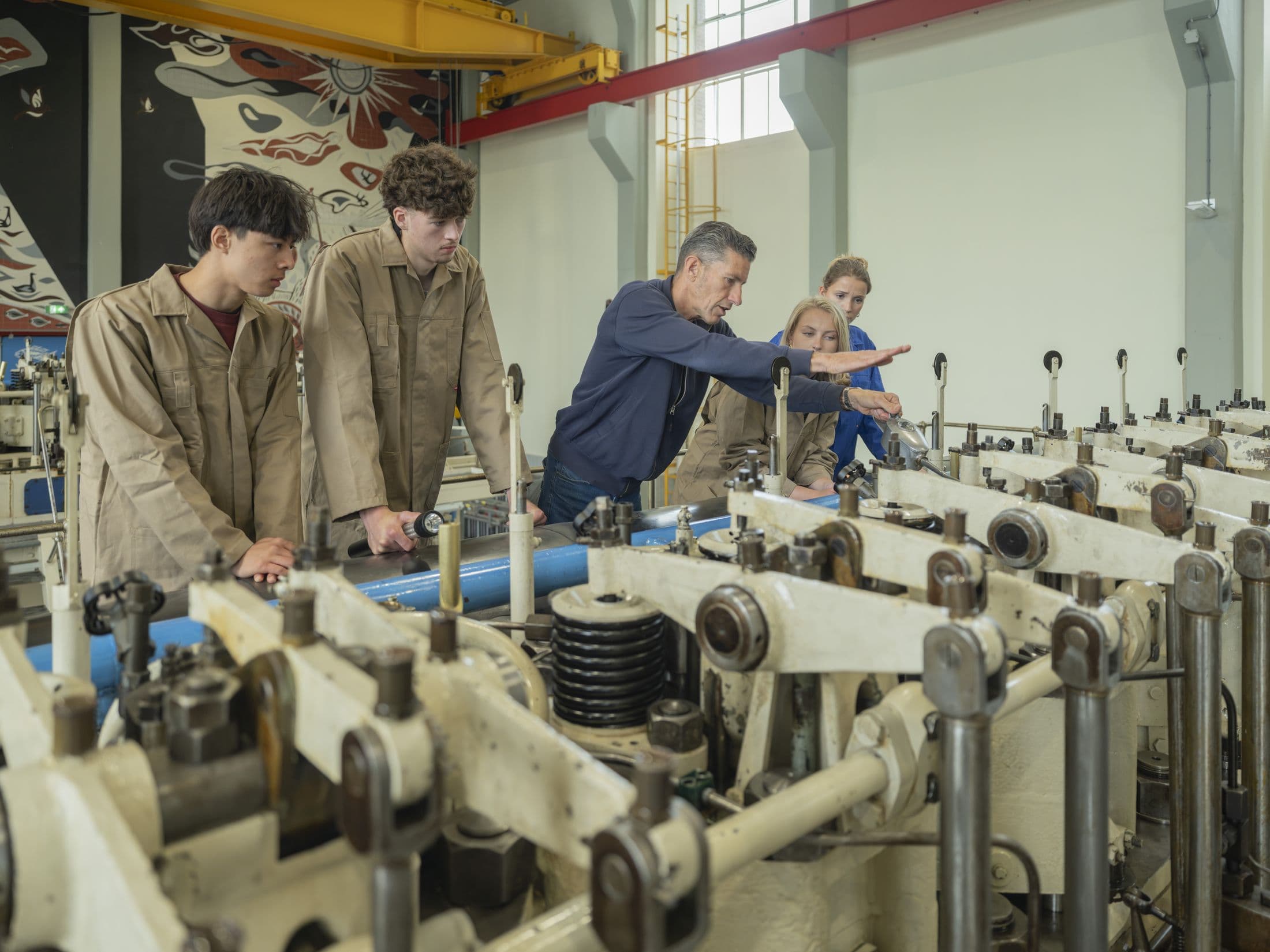Docent wijst studenten de weg in de machinehal van een gemaal